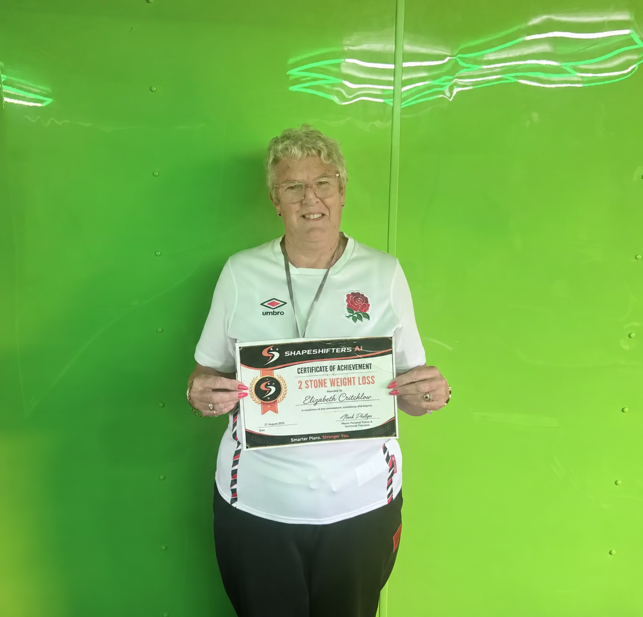 Elizabeth Critchlow holding her ShapeShifters two-stone weight-loss achievement certificate