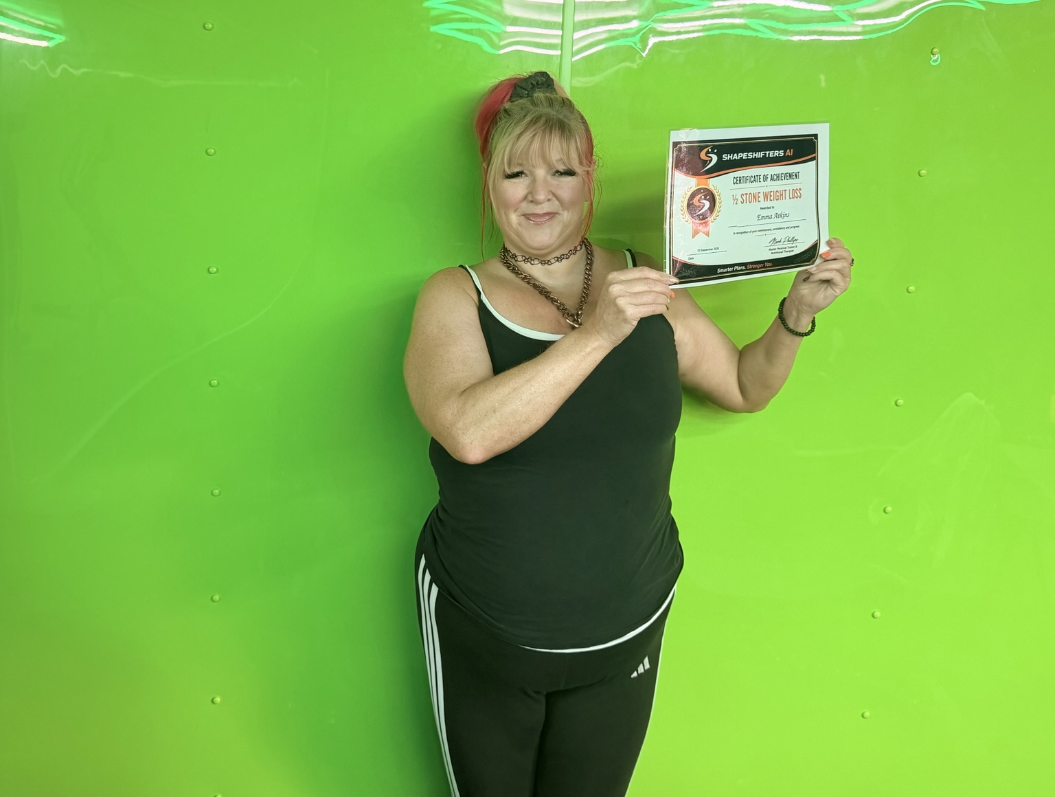 Emma Atkins holding her ShapeShifters half-stone weight-loss achievement certificate
