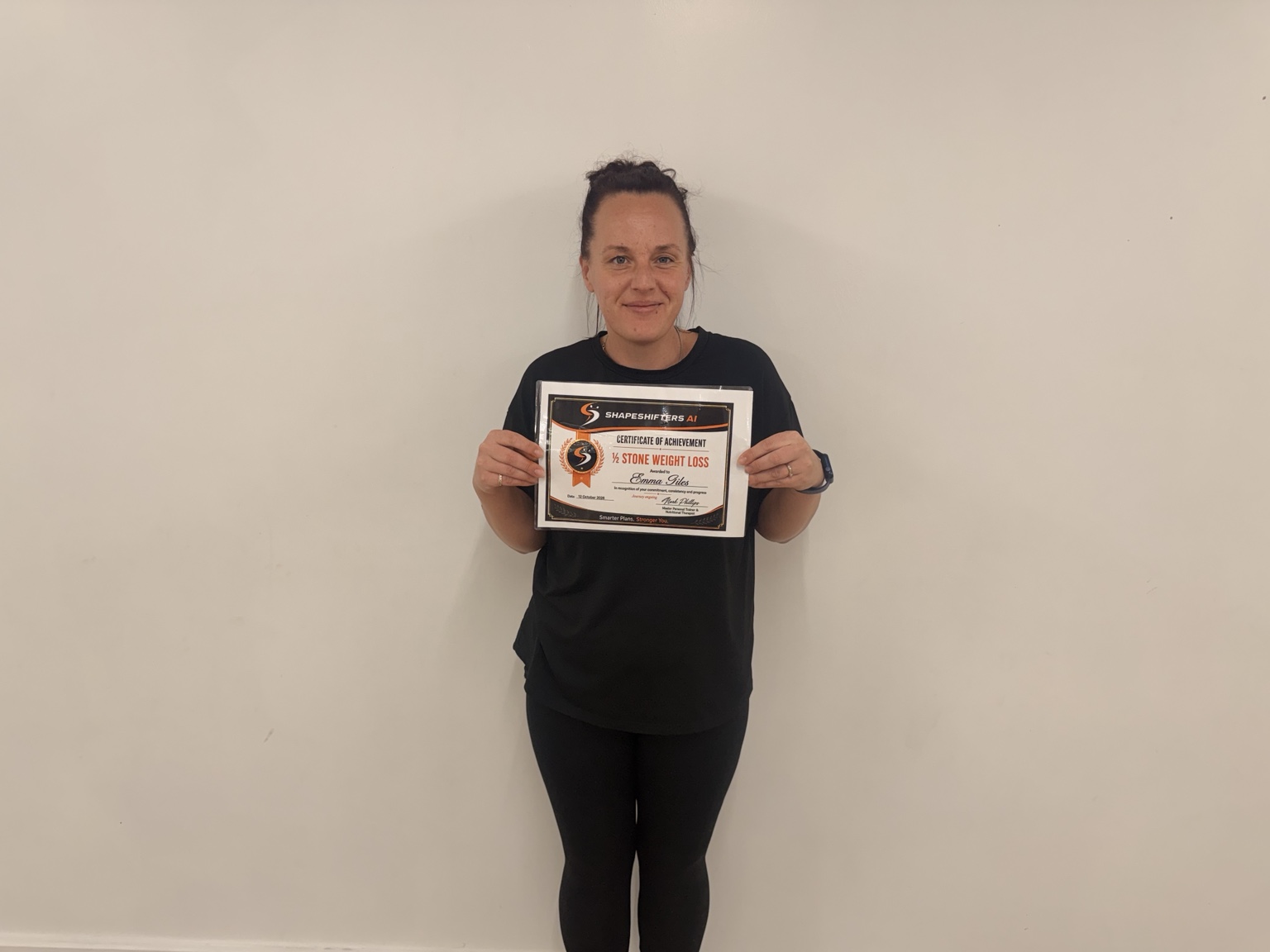 Emma Giles holding her ShapeShifters half-stone weight-loss achievement certificate