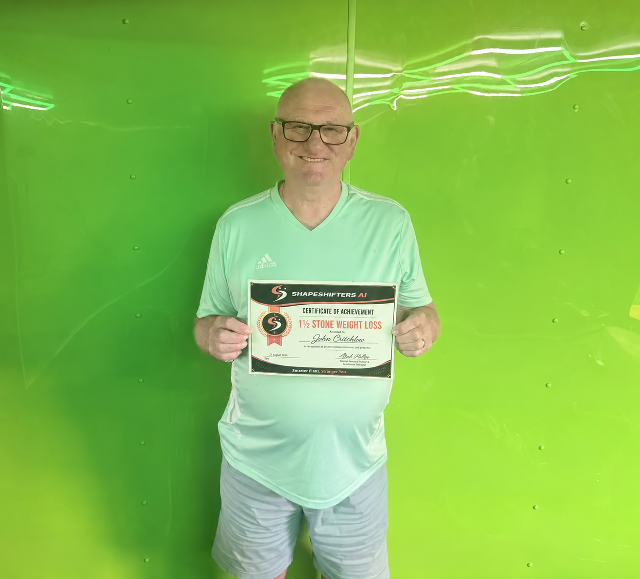 John Critchlow holding his ShapeShifters one-and-a-half-stone weight-loss achievement certificate