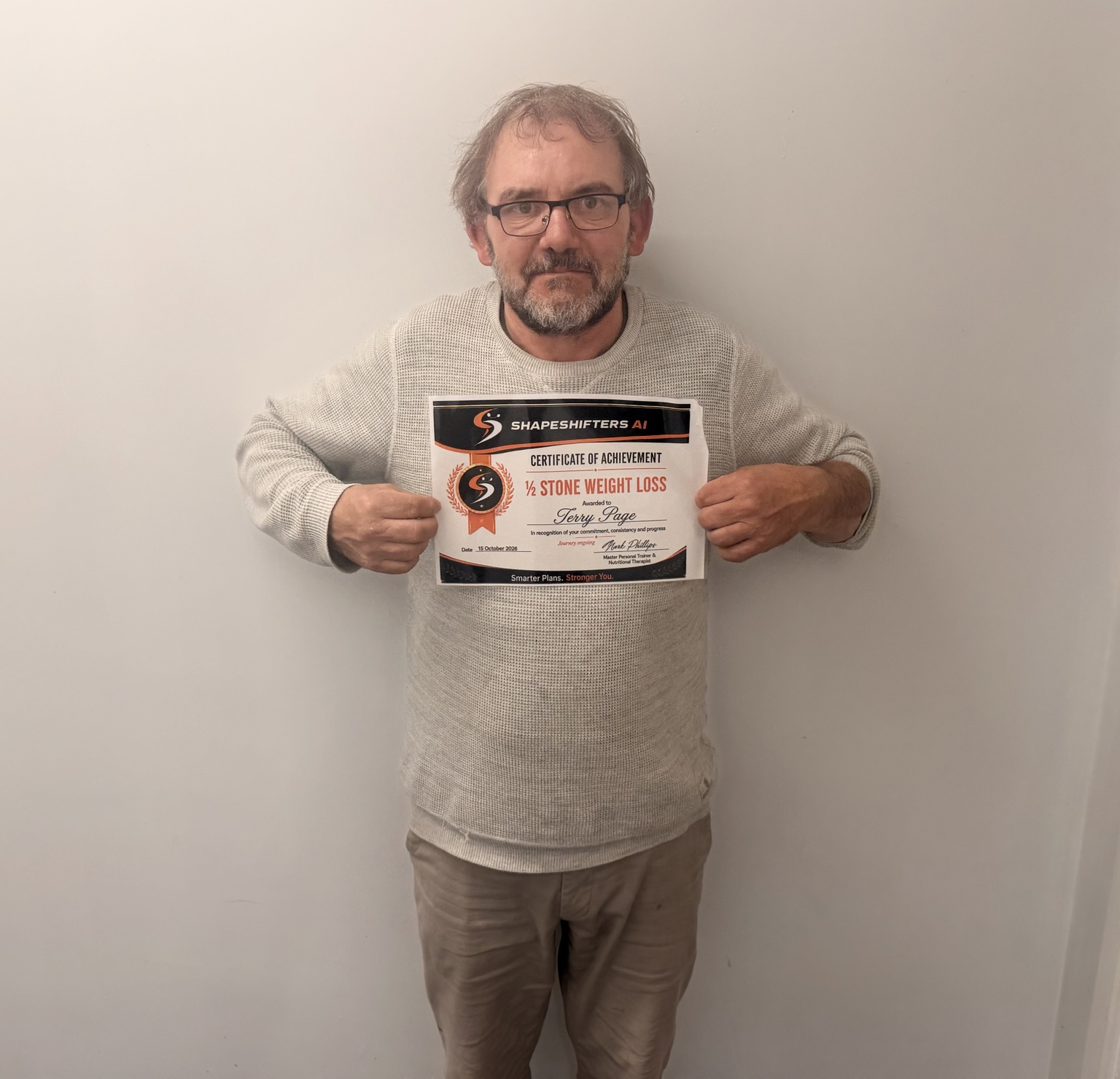Terry Page holding his ShapeShifters half-stone weight-loss achievement certificate
